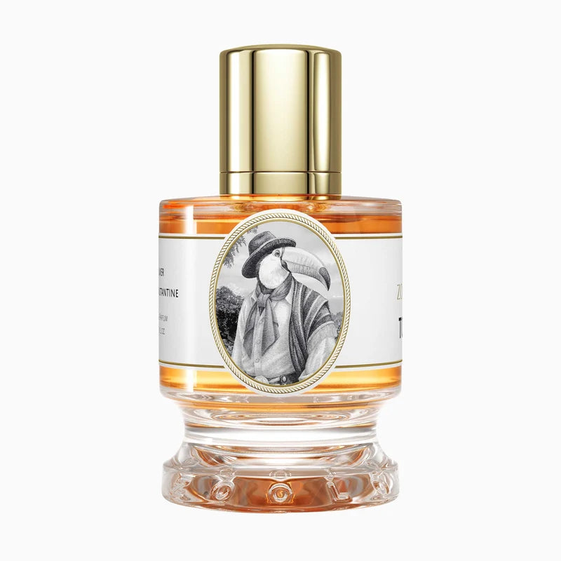 A clear glass perfume bottle with amber liquid, a shiny gold cap, and a white label featuring a black-and-white portrait of a man in a hat. The bottle is centered on a light gray background.
