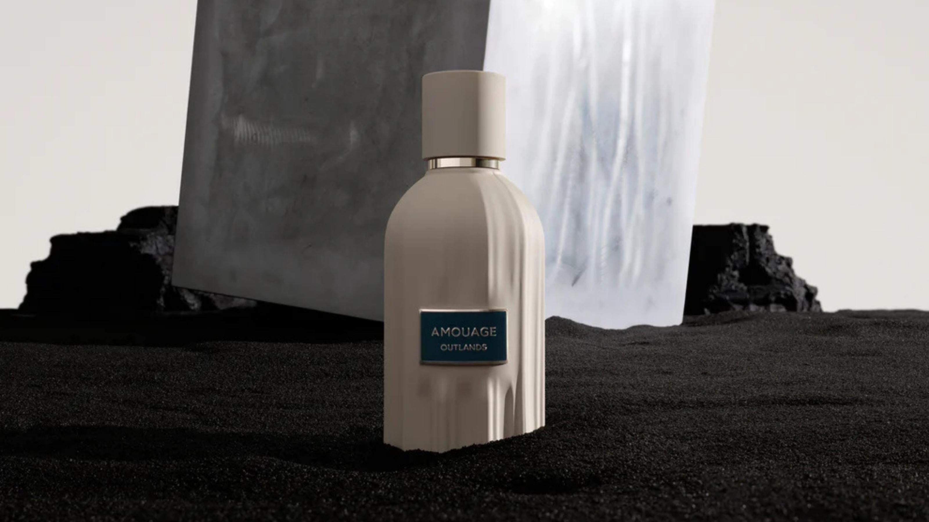 Silver perfume bottle with 'Amouage' label on a dark surface