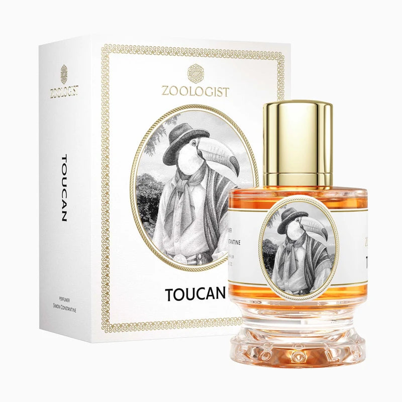 Zoologist Toucan perfume bottle and packaging box on a clean white background. The clear glass bottle contains amber-colored liquid and features a gold cap and a white label with a toucan illustration.