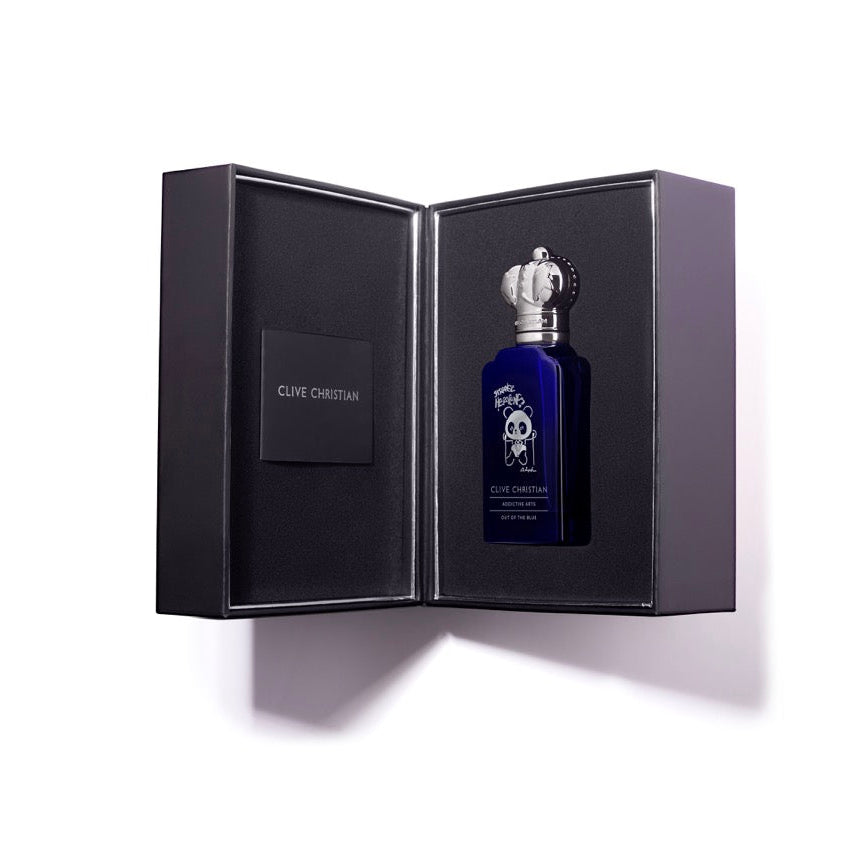 Blue perfume bottle with silver cap in an open black box on a white background