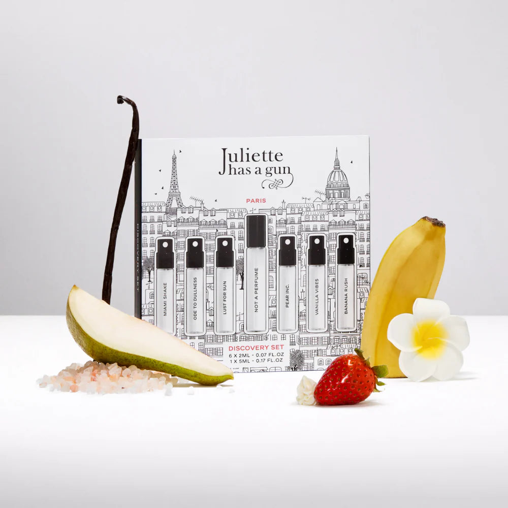 Juliette has a gun perfume set with vanilla bean, pear, banana, strawberry, and flower on a white background