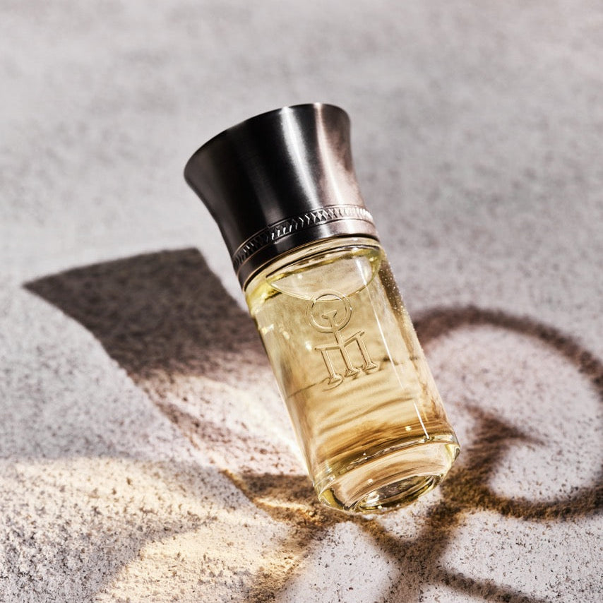 Perfume bottle with a metallic cap on a textured surface