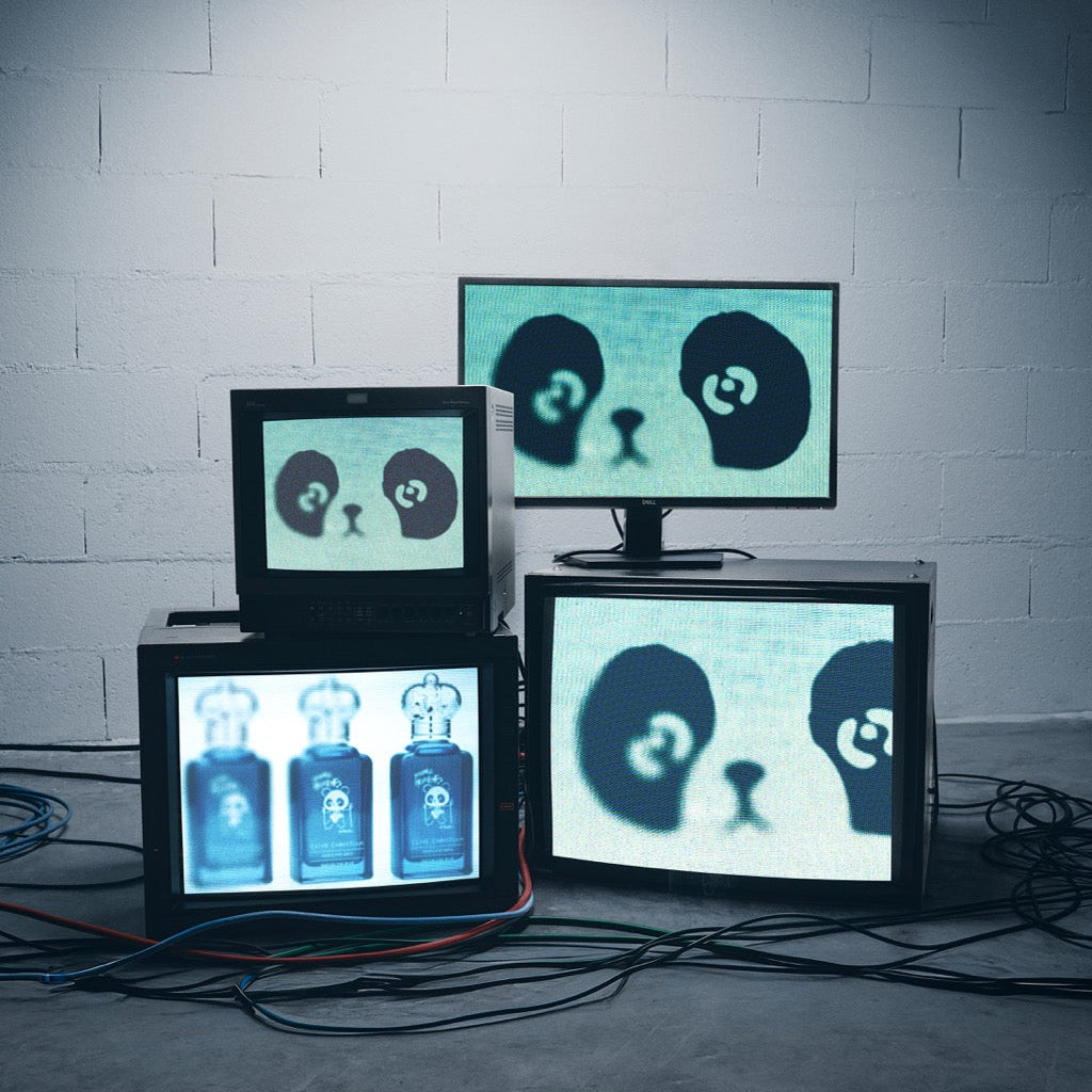 Multiple monitors displaying panda faces and bottles on a gray brick wall background