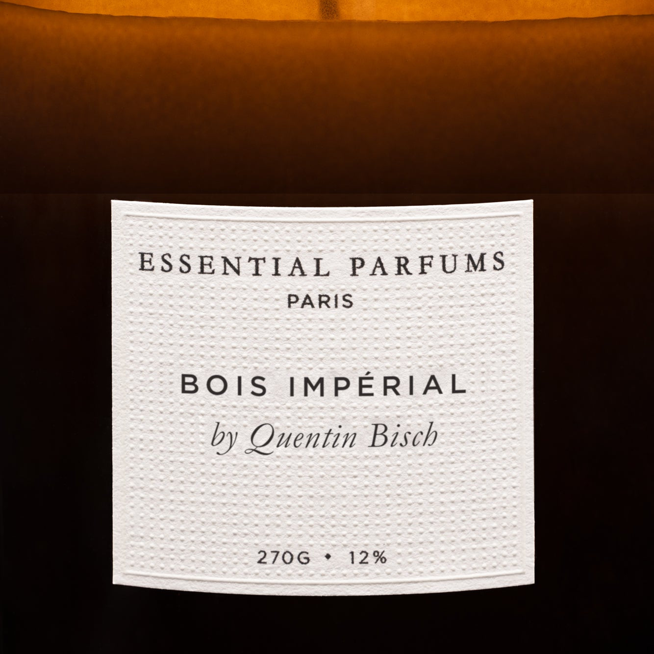 Candle with 'Essential Parfums Paris' label on a white background