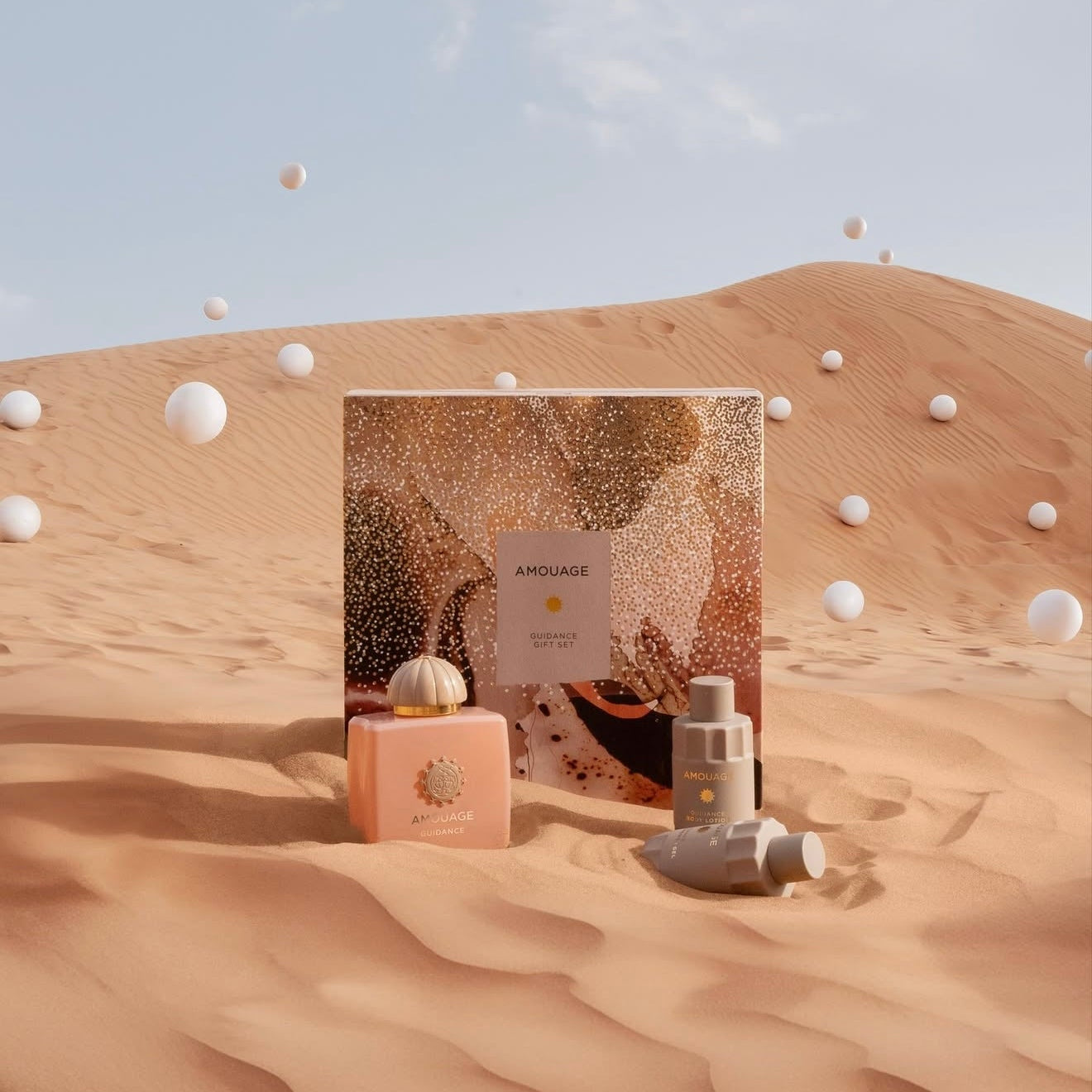 Cosmetic set with a pink bottle and gold packaging on a desert background
