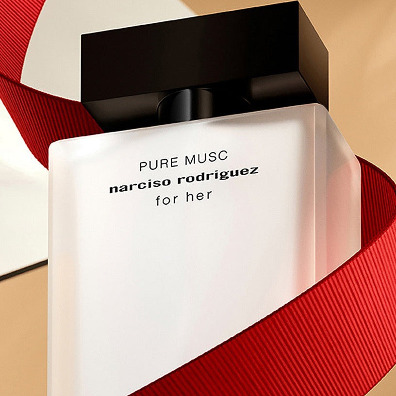 Perfume bottle of 'Pure Musc' by narciso rodriguez with a red ribbon on a beige background